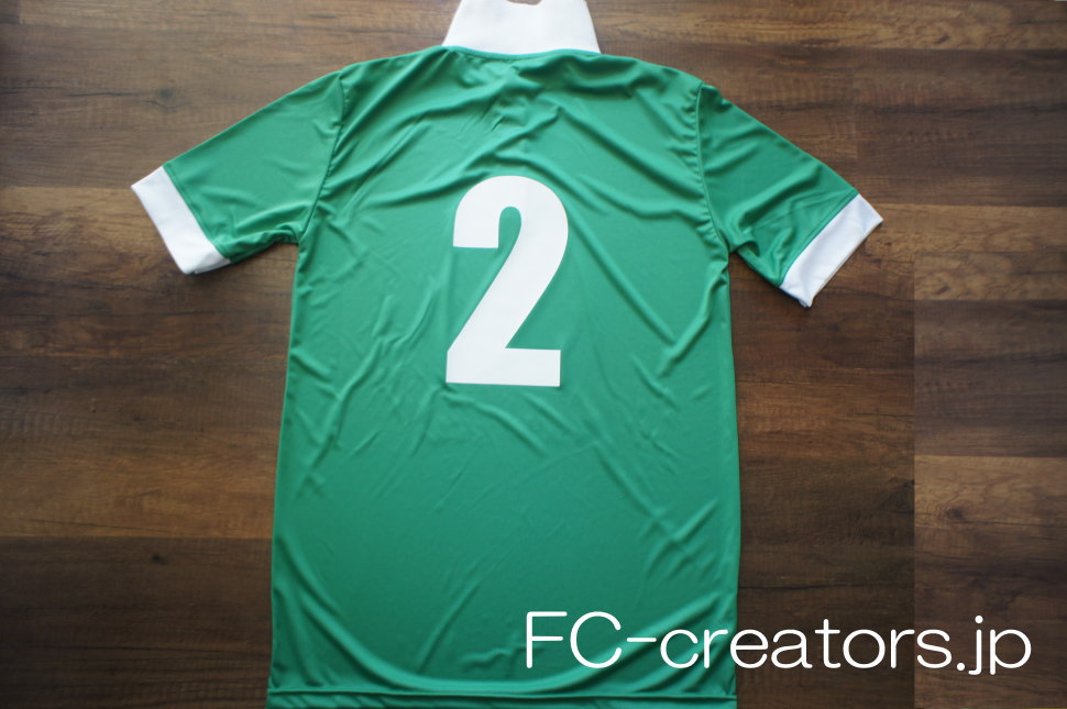 緑色のサッカーユニフォームの白い背番号