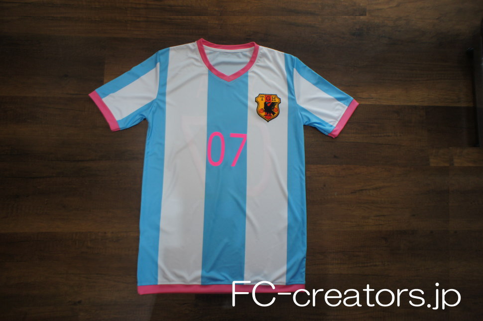 白と水色のストライプ柄サッカーシャツにチームのロゴマークをプリント