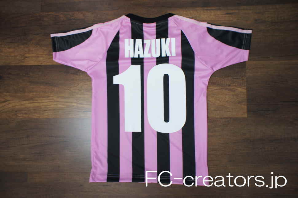 ピンクと黒のストライプ柄サッカーユニフォームにプリントした選手名と背番号