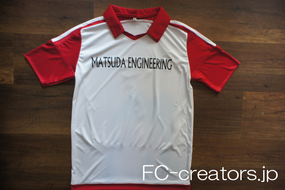 白色のサッカーユニフォーム 赤い襟付き 黒字のチーム名