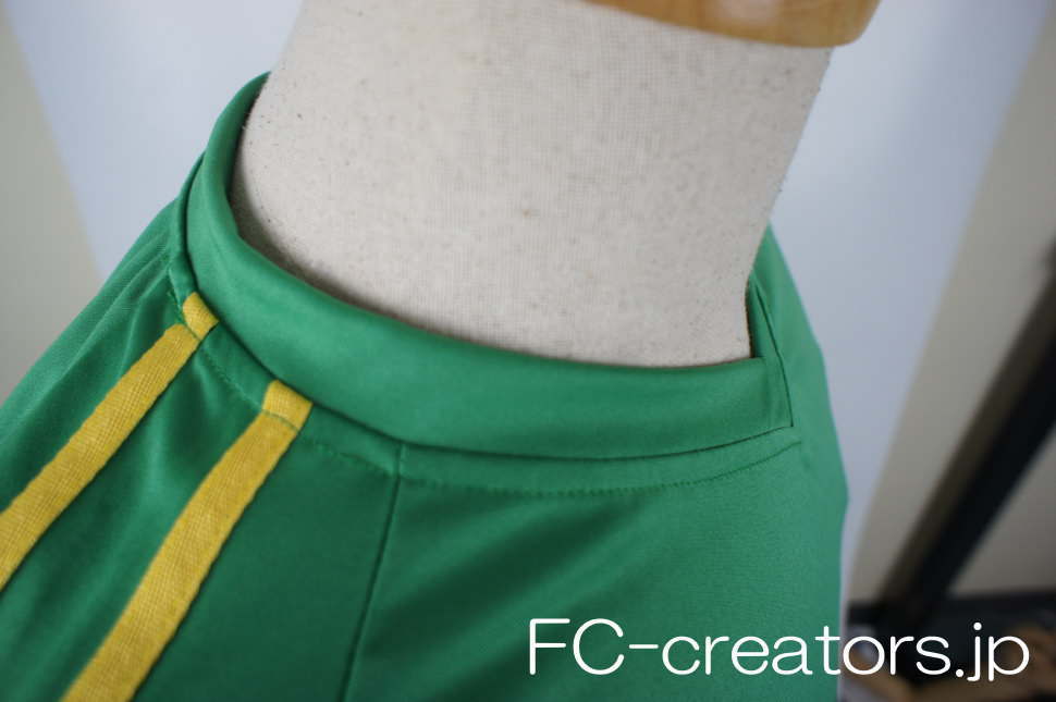 緑色のサッカーユニフォーム ゲームシャツに黄色い二本線を縫製した肩口