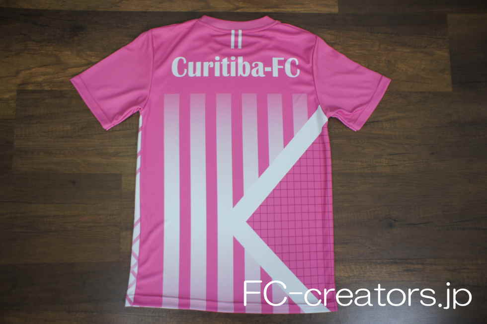 ピンクと白のサッカーユニフォーム背面に白地のチーム名をプリント
