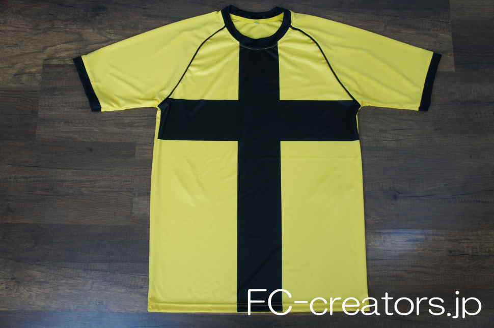 黄色に黒地の十字柄を昇華プリントしたサッカー部のユニフォーム ラグラン