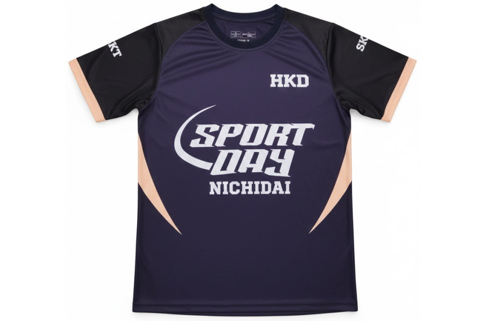 クラスTシャツ 正面全体図:ネイビーとベージュの切替デザイン。高品質な全面昇華プリントで「SPORT DAY NICHIDAI」ロゴを表現。校内イベント・修学旅行の団体服に最適。