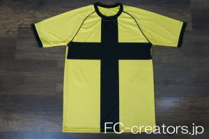 黄色に黒の十柄をプリントした半袖サッカーシャツ